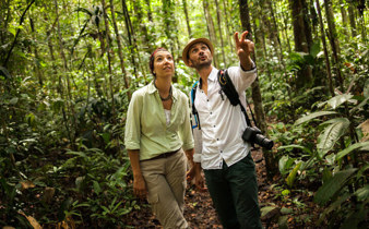 Visitors on a guided trek through the Peruvian Amazon rainforest, learning about local wildlife and plants. 