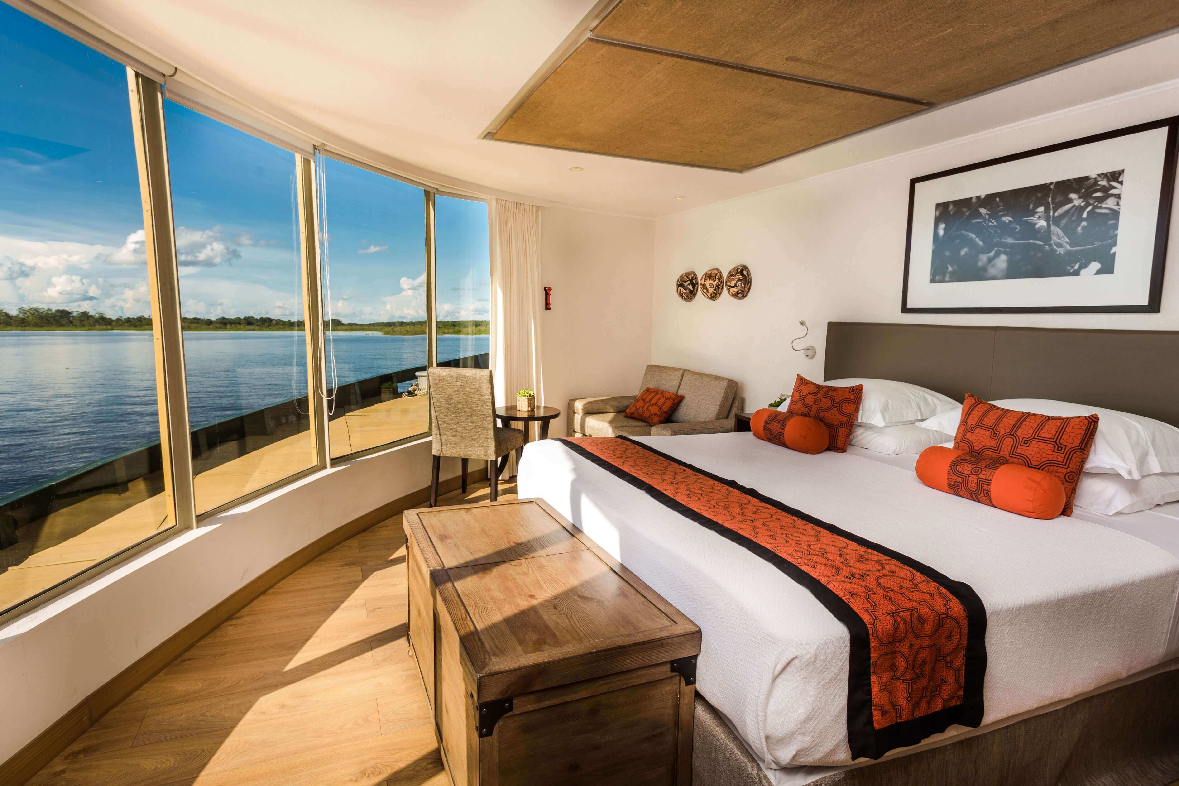 Expedition cruise in the stunning corner suite with expansive views of the rainforest