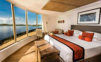 Expedition cruise in the stunning corner suite with expansive views of the rainforest