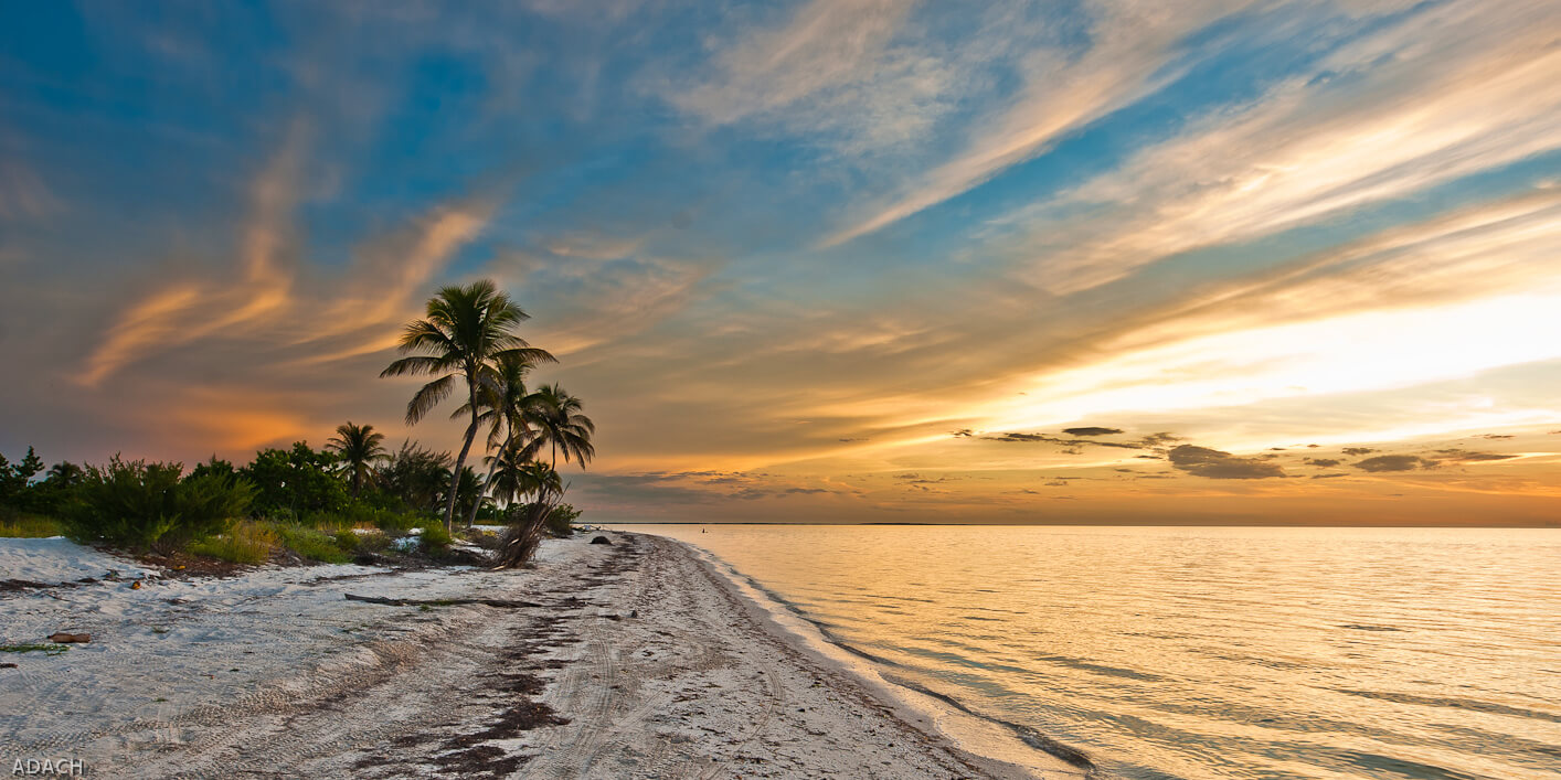 Sunset over the sandy beaches and palm trees of Holbox Island, Yucatan, Mexico, with dramatic evening sky. 