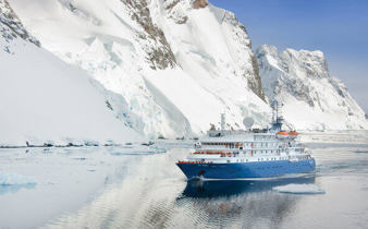 The Sea Spirit cruises through Antarctica's icy water past towering glaciers. 