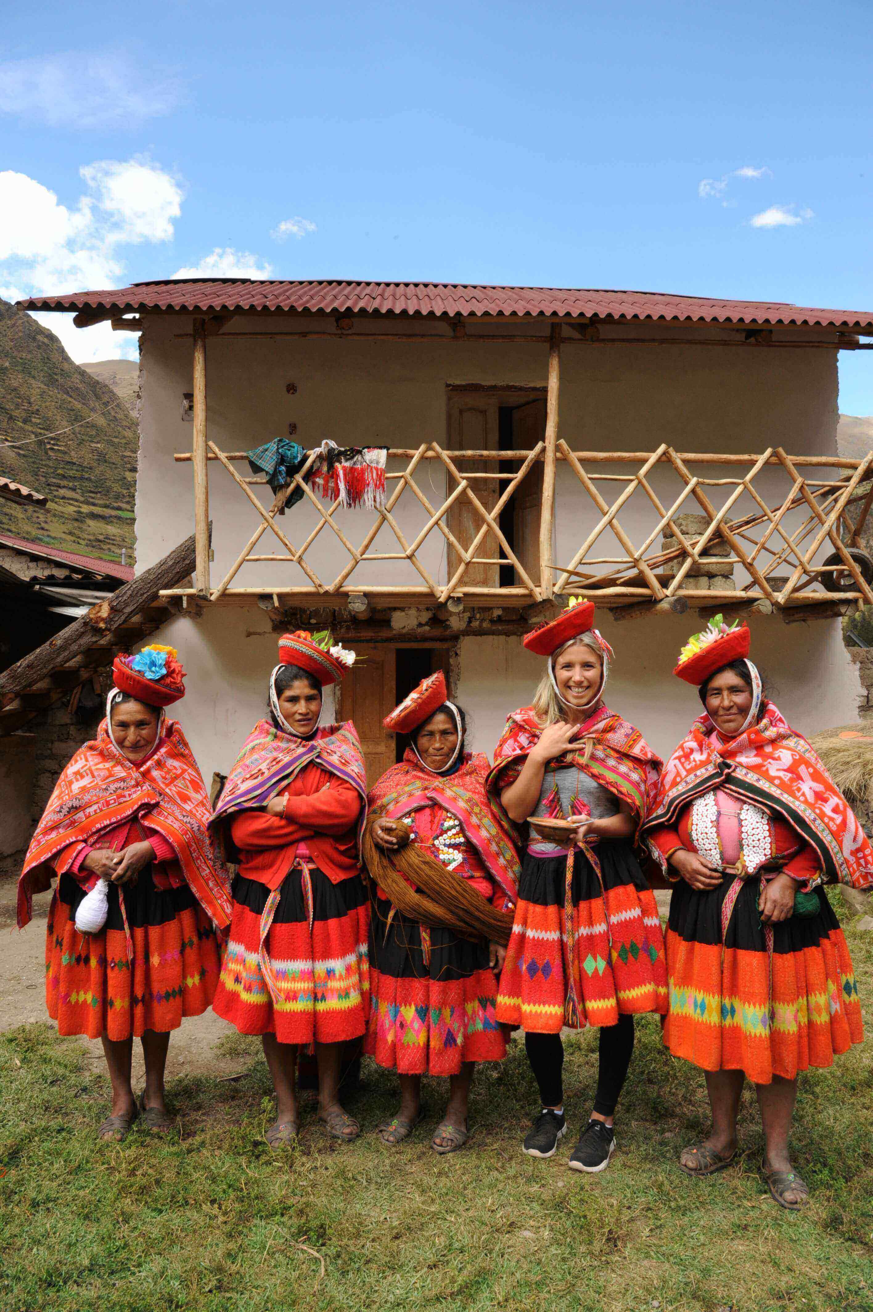 Local Andean women and tourist in traditional Quechua clothing, Sacred Valley, Peru. 