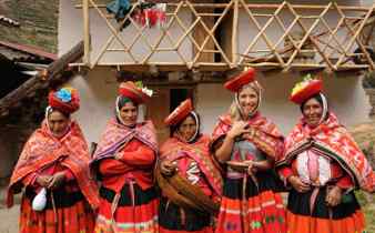 Local Andean women and tourist in traditional Quechua clothing, Sacred Valley, Peru. 