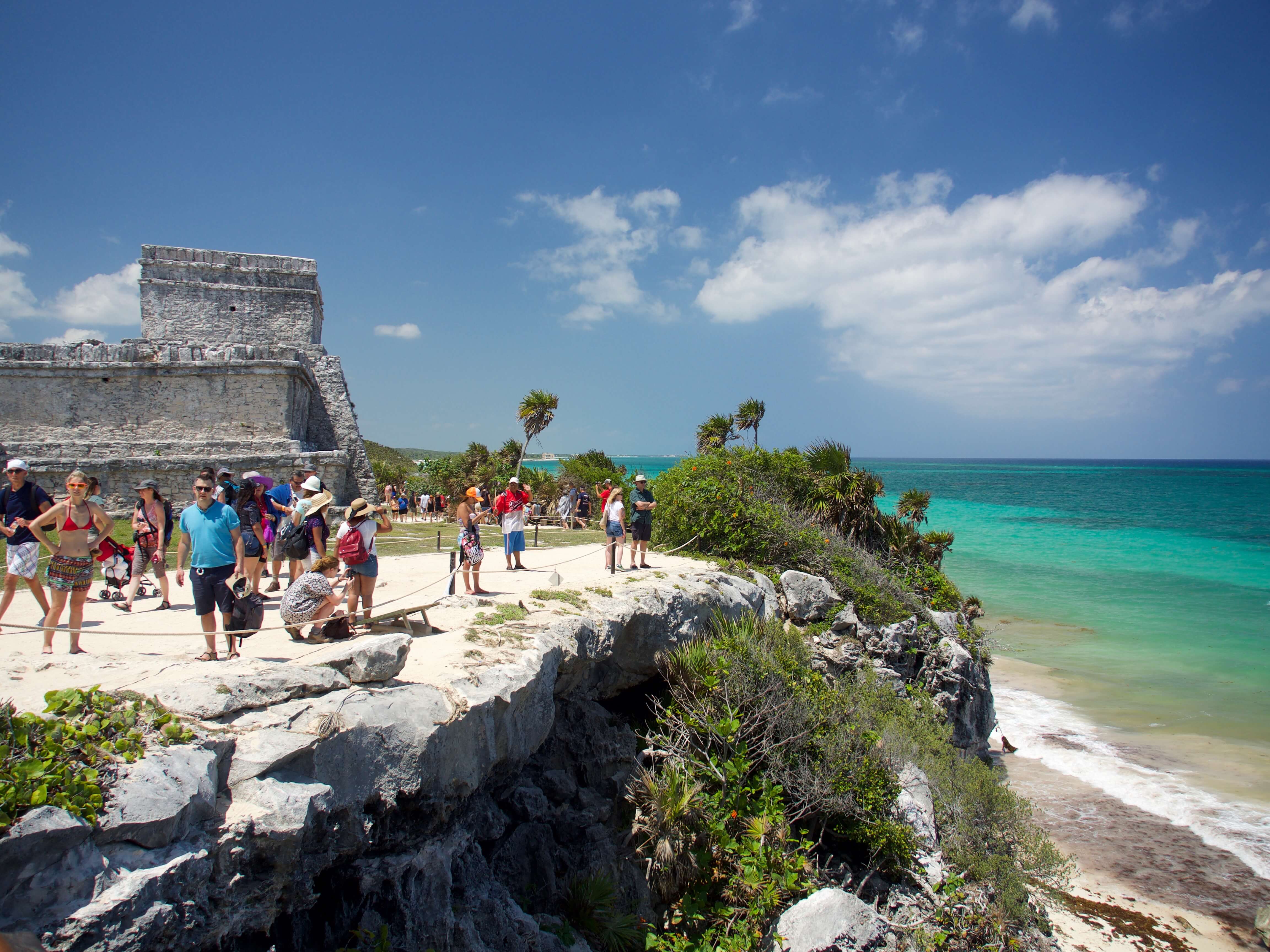 Visitors explore the cliffside Mayan ruins of Tulum overlooking the turquoise Caribbean Sea in Mexico's Yucatan Peninsula. 