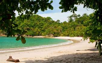 Secluded white sand beach with turquoise water and jungle backdrop at Manuel Antonio, Costa Rica. 
