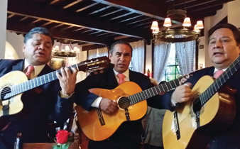Three traditional Mexican guitarists perform indoors, capturing the spirit and musical heritage of Mexico. 