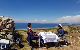 Private picnic setup with panoramic views of Lake Titicaca in the Peruvian highlands. 