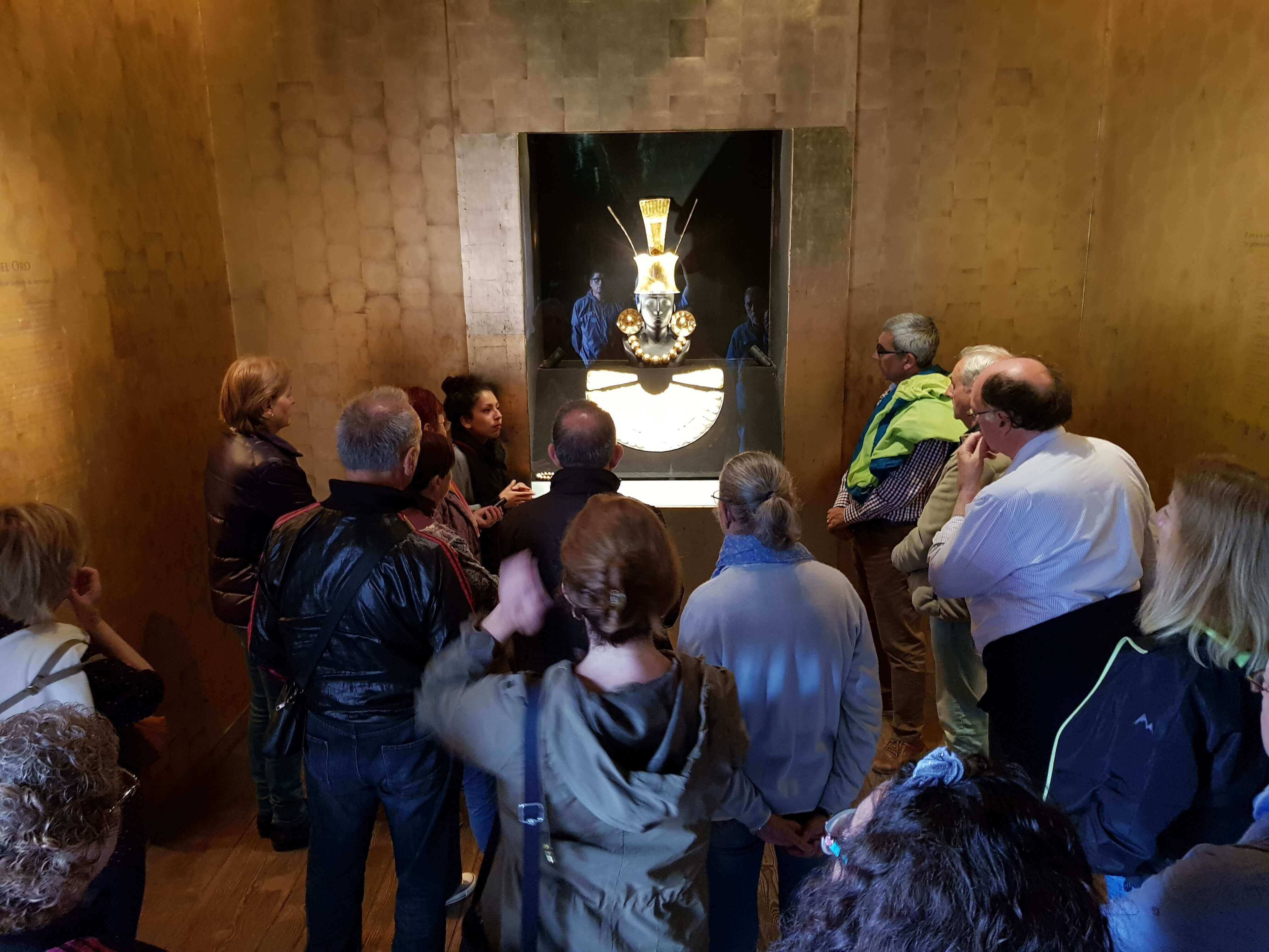 Tourists viewing an ancient golden mask exhibit in a museum in Lima, Peru. 