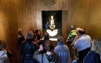 Tourists viewing an ancient golden mask exhibit in a museum in Lima, Peru. 