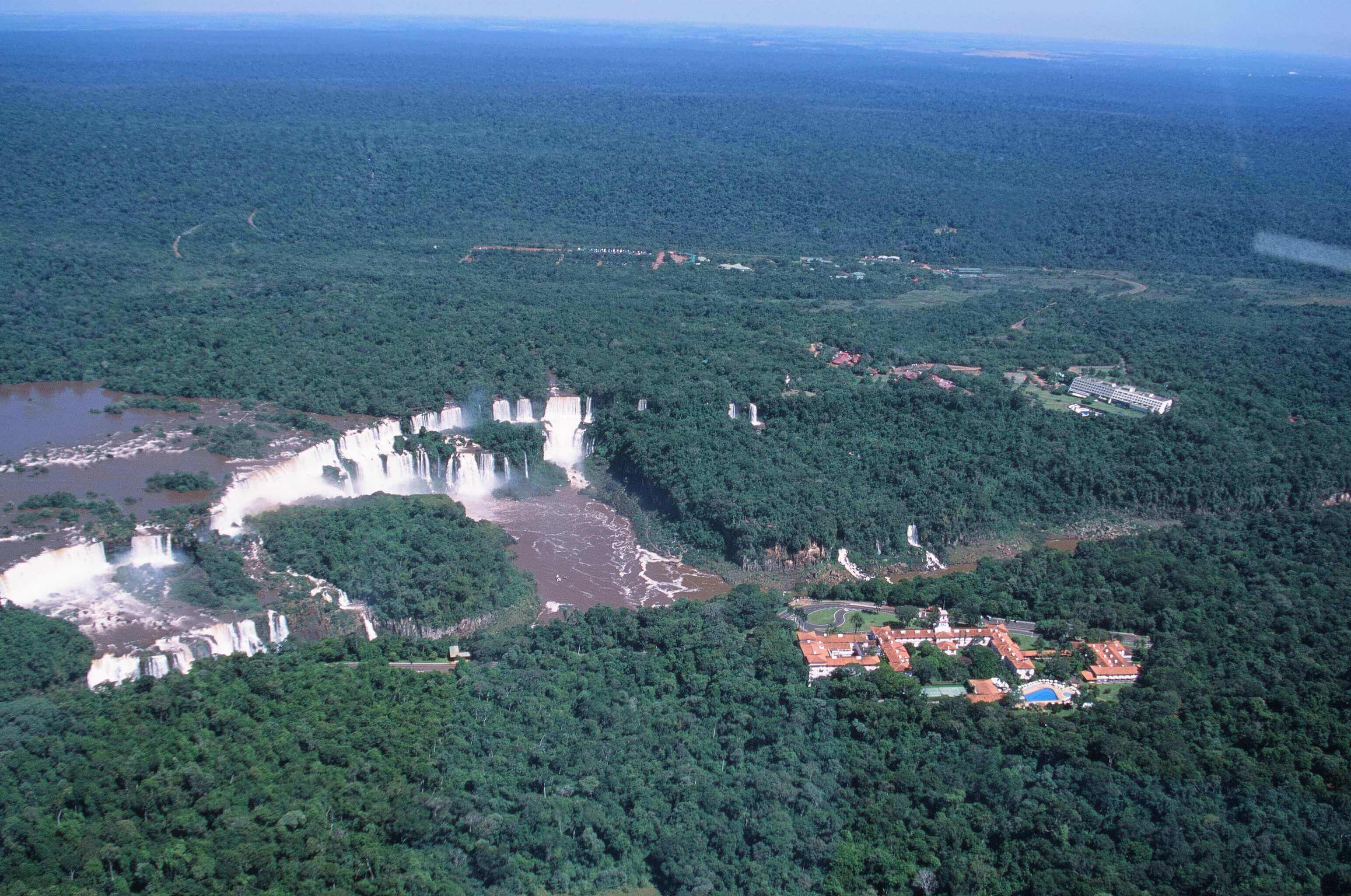 Aerial view of Brazil's Iguassu Falls and rainforest lodges nestled nearby. 