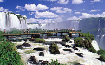 Visitors walk the boardwalk at Iguassu Falls, Brazil, surrounded by thunderous waterfalls. 